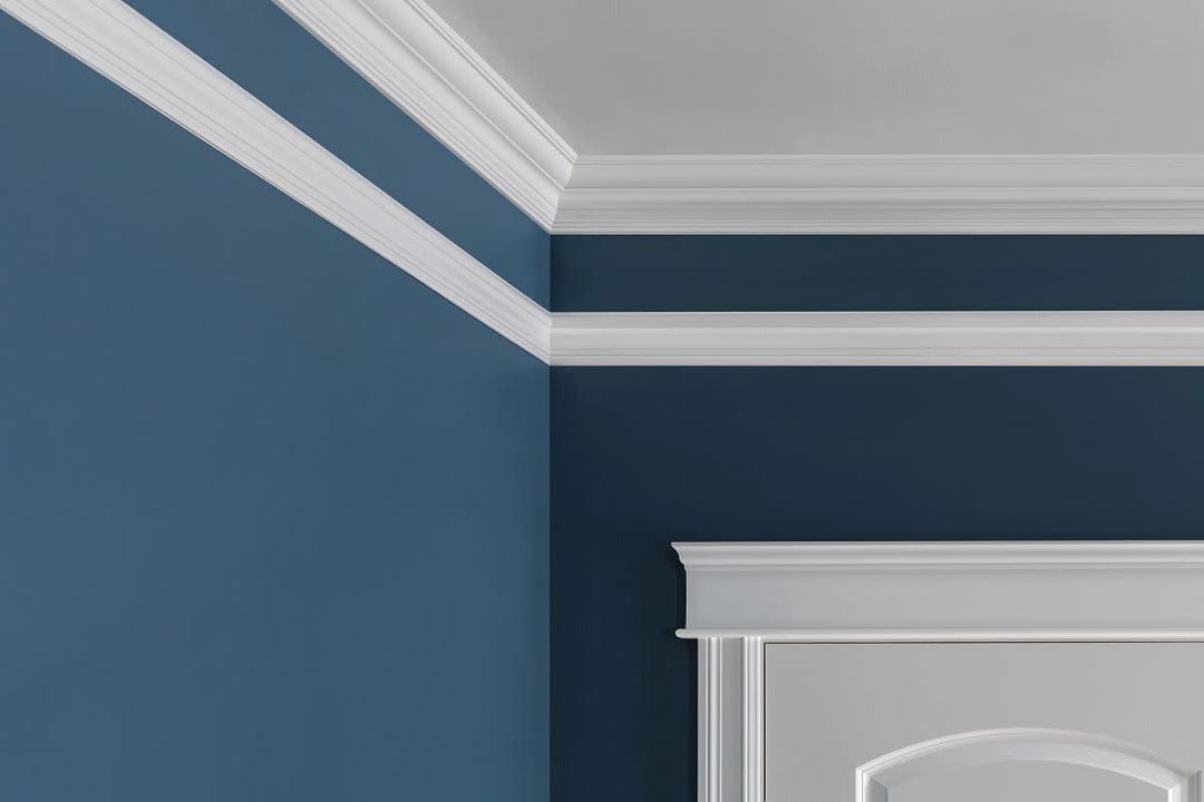 White crown molding on a blue wall with a white-framed door.