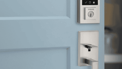 A modern metal door handle and electronic keypad lock are installed on a light blue door.